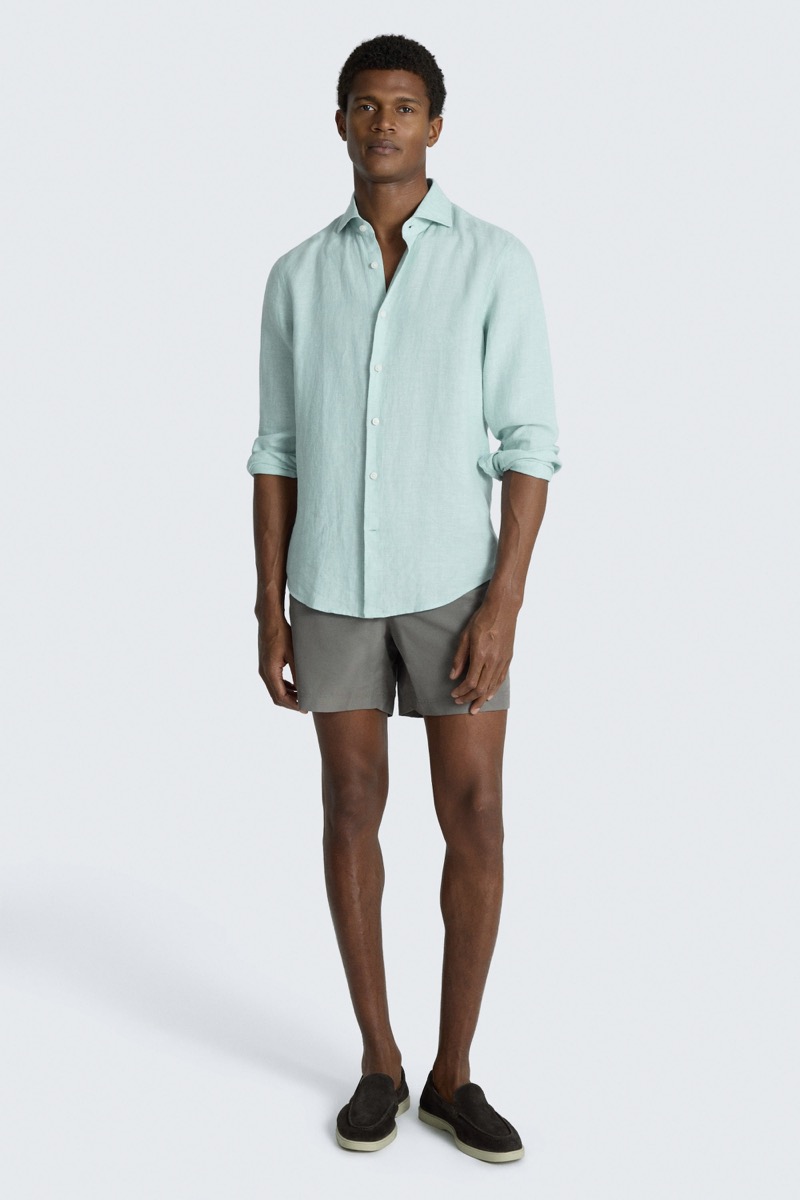 Model wears short-sleeve linen shirt with shorts and suede loafers