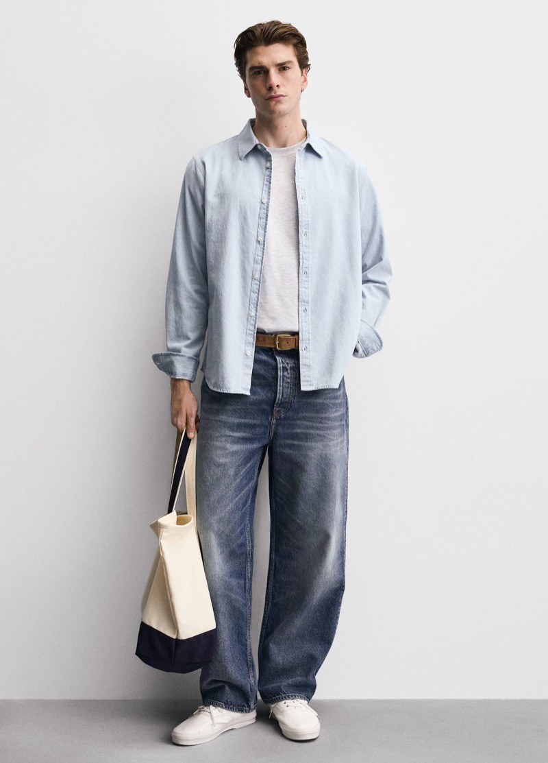 light blue denim shirt worn open over white tee with relaxed jeans outfit for men