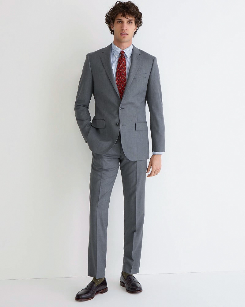 Model wears a gray Ludlow suit with a striped Oxford shirt, red tie, and black leather loafers