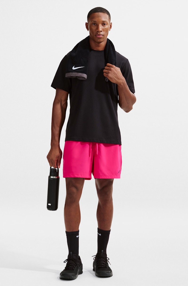 man wearing hot pink athletic training shorts with a T-shirt and sneakers