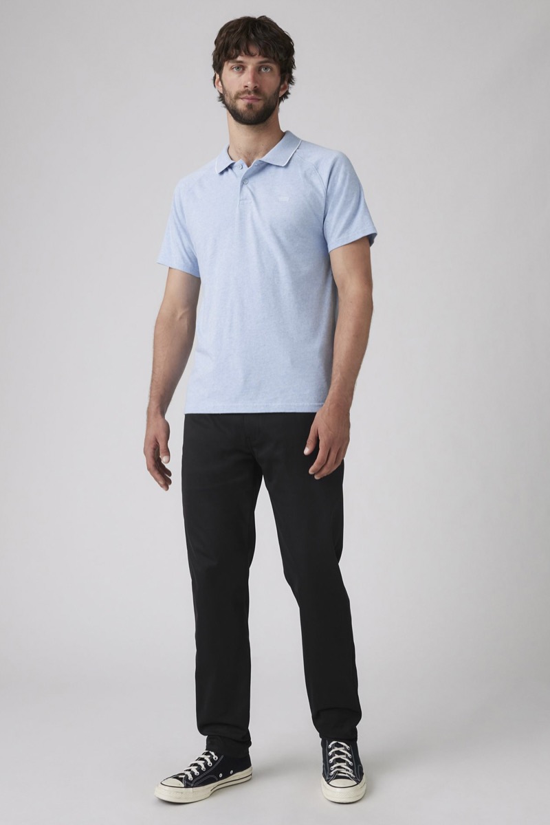 Man wearing slim black chinos with light blue heather polo shirt and black Converse Chuck 70 sneakers