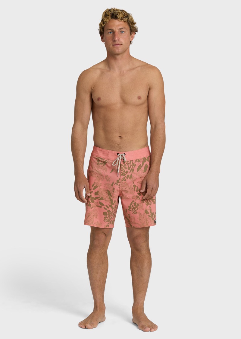 man wearing printed coral board shorts