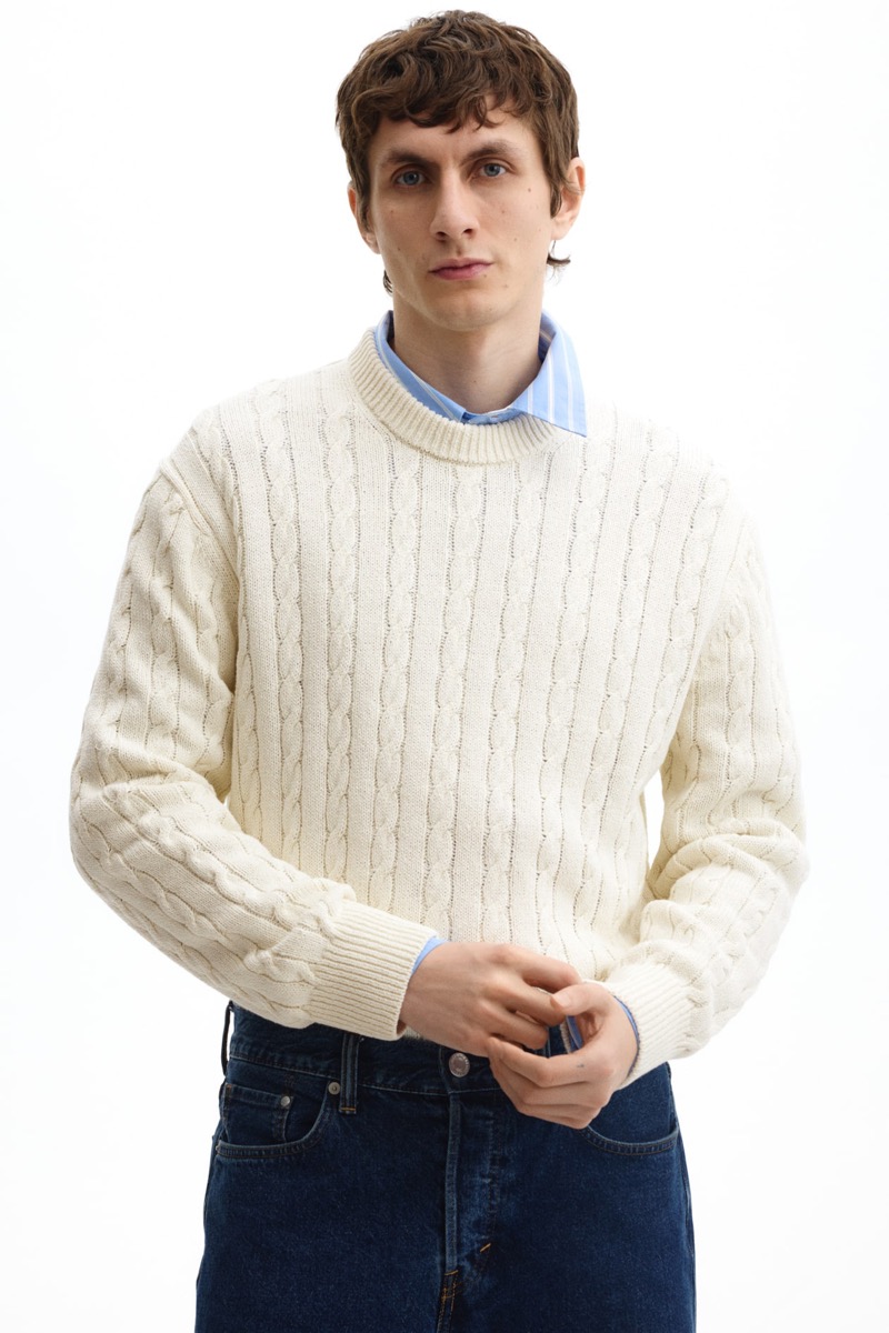 Cream cable knit crewneck sweater over a blue shirt collar