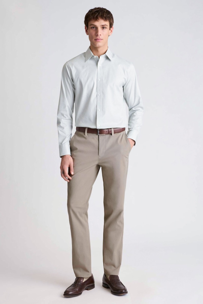 model wears chinos with light gray dress shirt and dark brown leather loafers