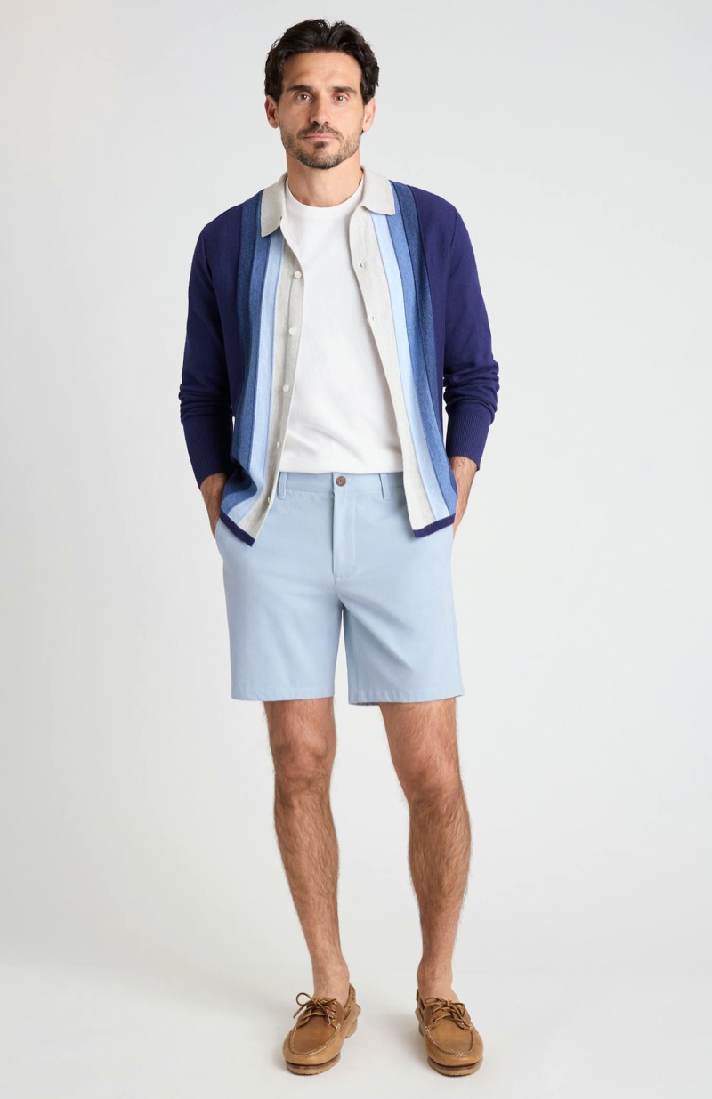 man wearing light blue chino shorts with a button-through knit shirt and boat shoes