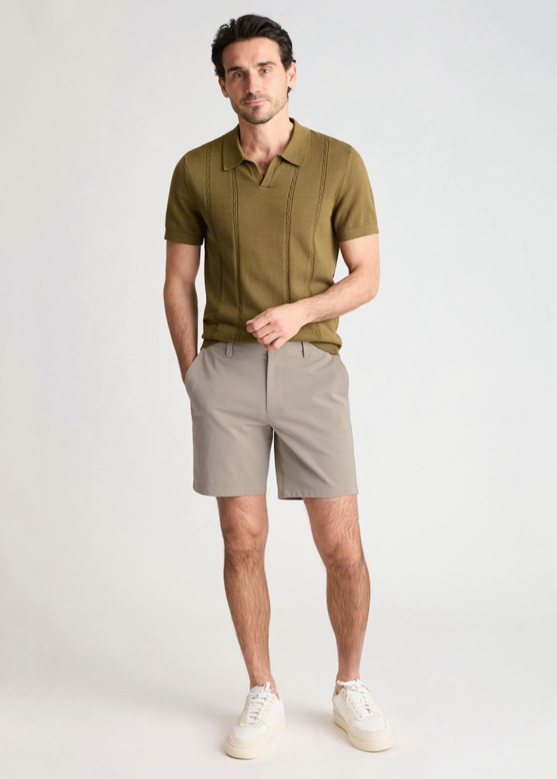 Man wearing stone chino shorts with an olive knit polo and white sneakers