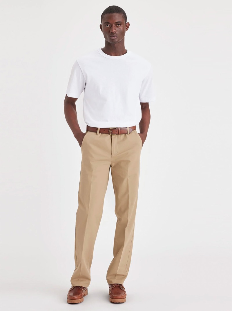 model wears pleated khakis with a white t-shirt and brown leather shoes