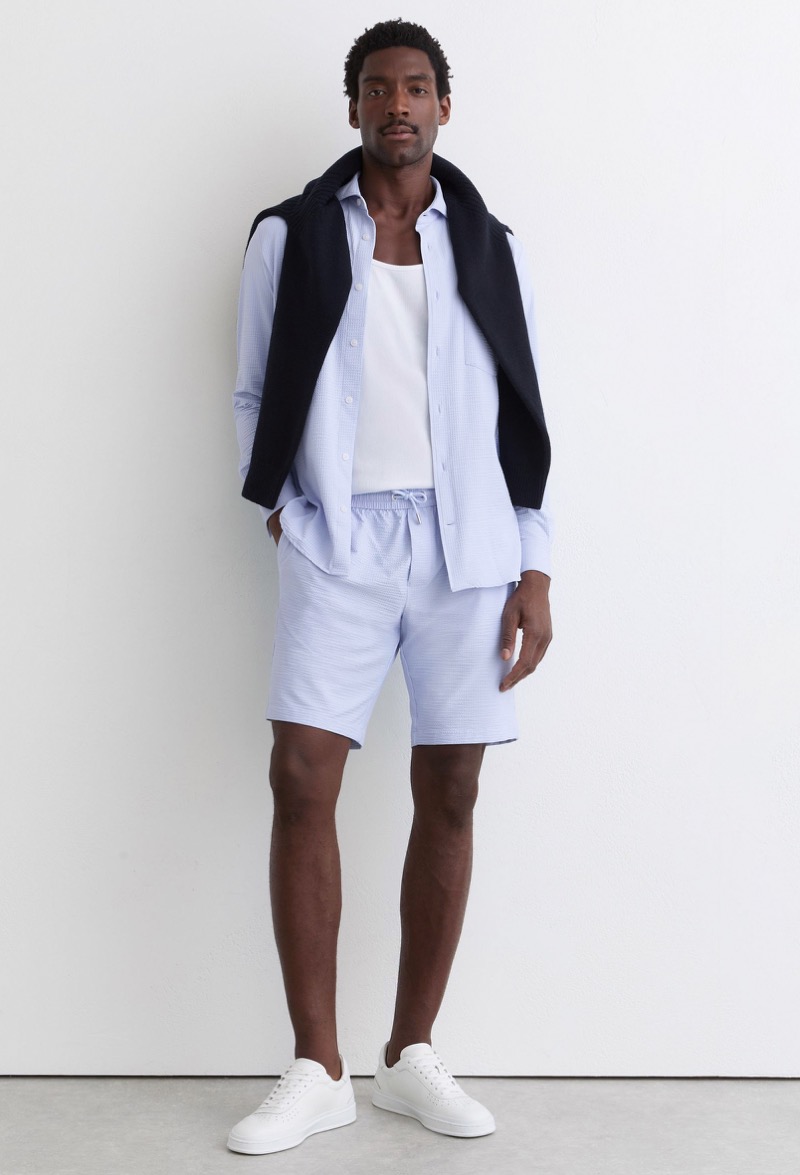 man wearing seersucker shorts with a matching shirt and white sneakers