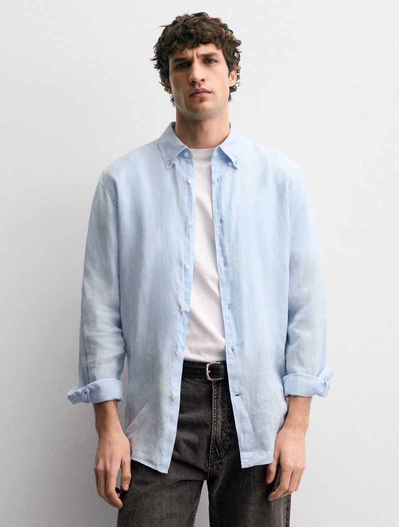 man wearing light blue linen shirt with cuff folded back once using the simple fold method