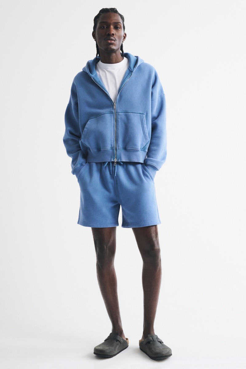 Man wearing a washed blue zip hoodie over a white tee with matching blue fleece shorts and dark grey suede Birkenstock Boston clogs