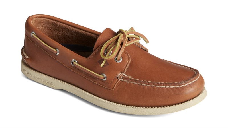 A light tan leather two-eyelet boat shoe with rawhide laces threaded around the collar, hand-sewn moccasin construction, and a white siped rubber sole.