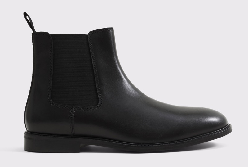 A black smooth-leather Chelsea boot in side profile with a black elastic side gusset, a fabric heel pull tab, and a clean almond toe on a low rubber sole.