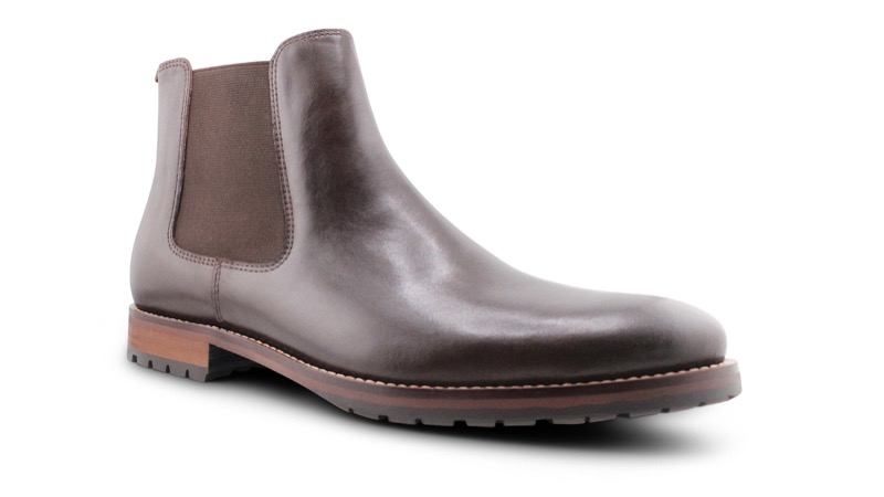 A single dark brown smooth-leather Chelsea boot in three-quarter view with a taupe elastic side gusset, a fabric heel pull tab, a clean almond toe, and a lugged rubber sole on a low stacked welt.
