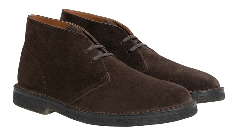 A pair of dark brown suede desert boots with two-eyelet lacing, an unlined upper, and a natural crepe rubber sole in a contrasting dark tone.