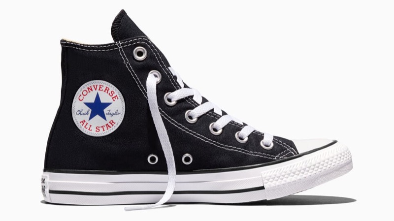 A black canvas high-top sneaker with a white round Chuck Taylor All Star ankle patch, white laces, a white toe cap, and a white rubber foxing stripe.