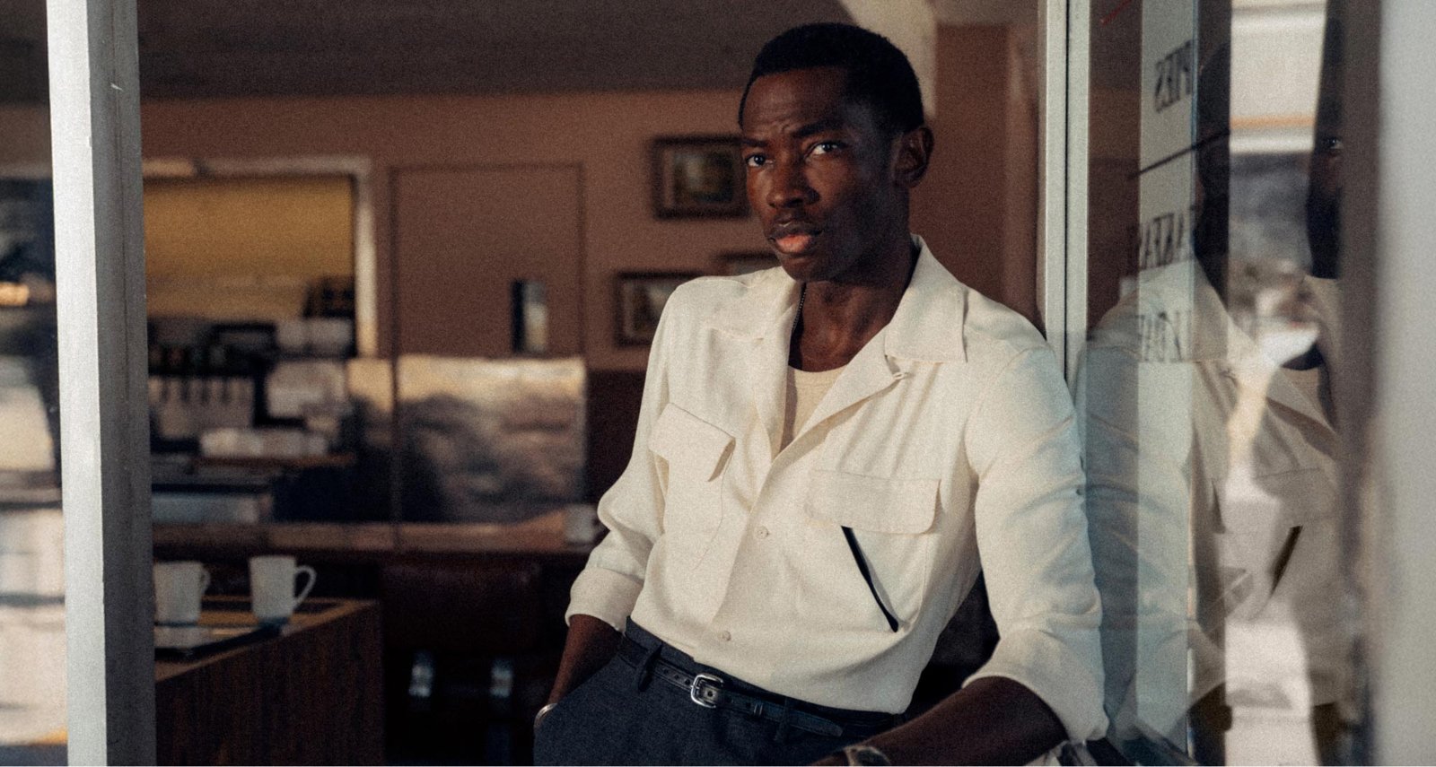 The natural rayon camp shirt catches the light beside a diner window.