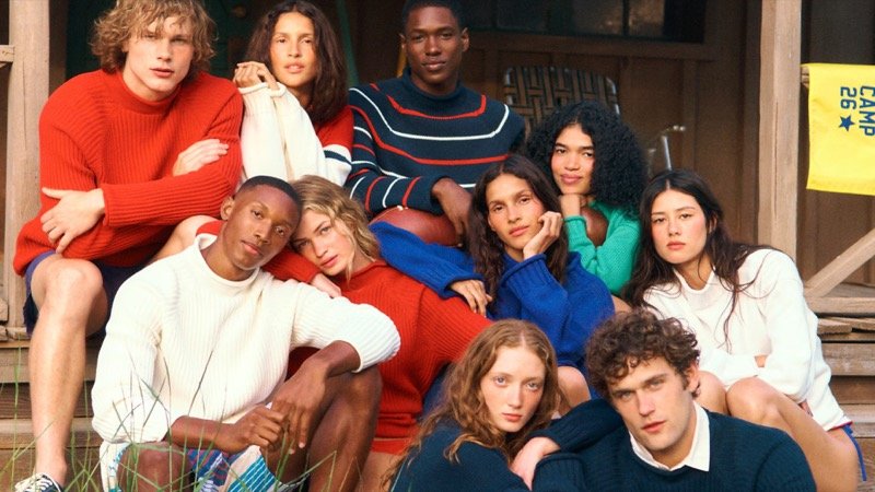 Bright knitwear and stripes fill the campaign’s cabin-steps portrait.