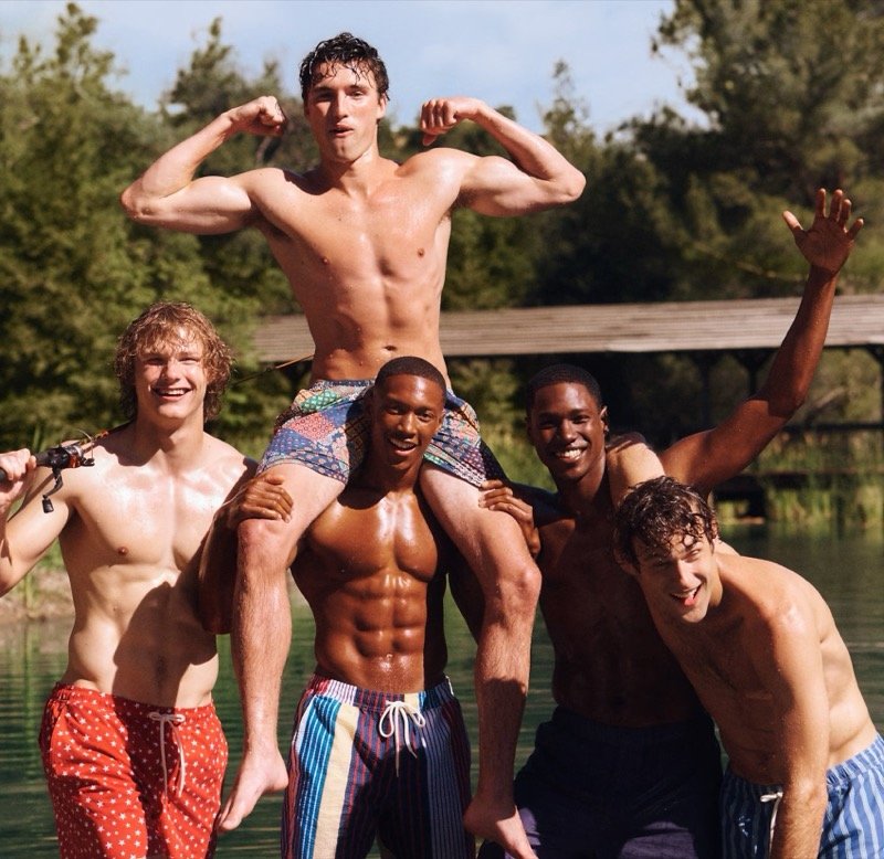 Patterned swim trunks bring color to a group portrait by the lake.