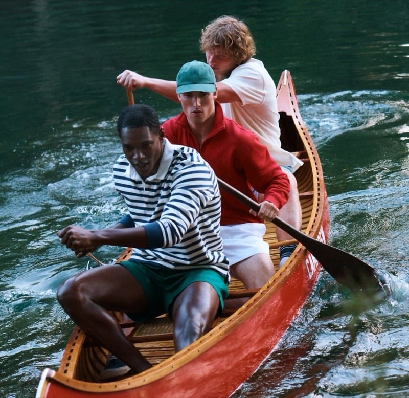 Striped rugby, red knitwear, and a white sweater share a canoe.