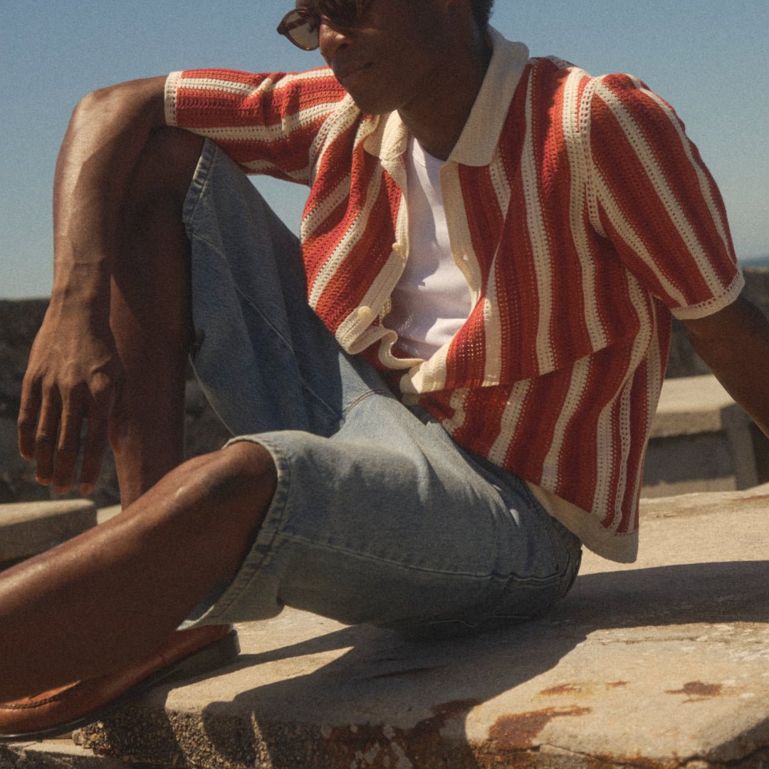 Orange-and-ecru crochet stripes sit above light blue denim shorts.